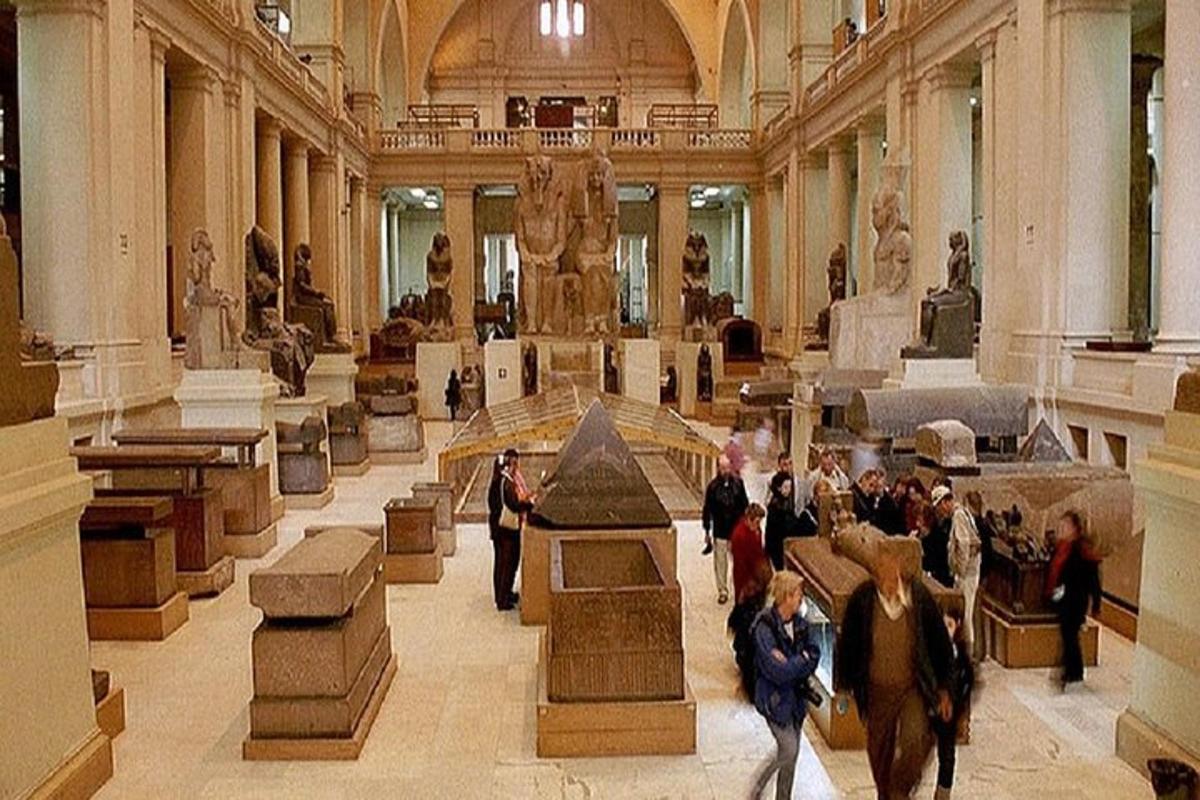 μια ομάδα ανθρώπων που περπατούν γύρω από ένα μουσείο με αντικείμενα