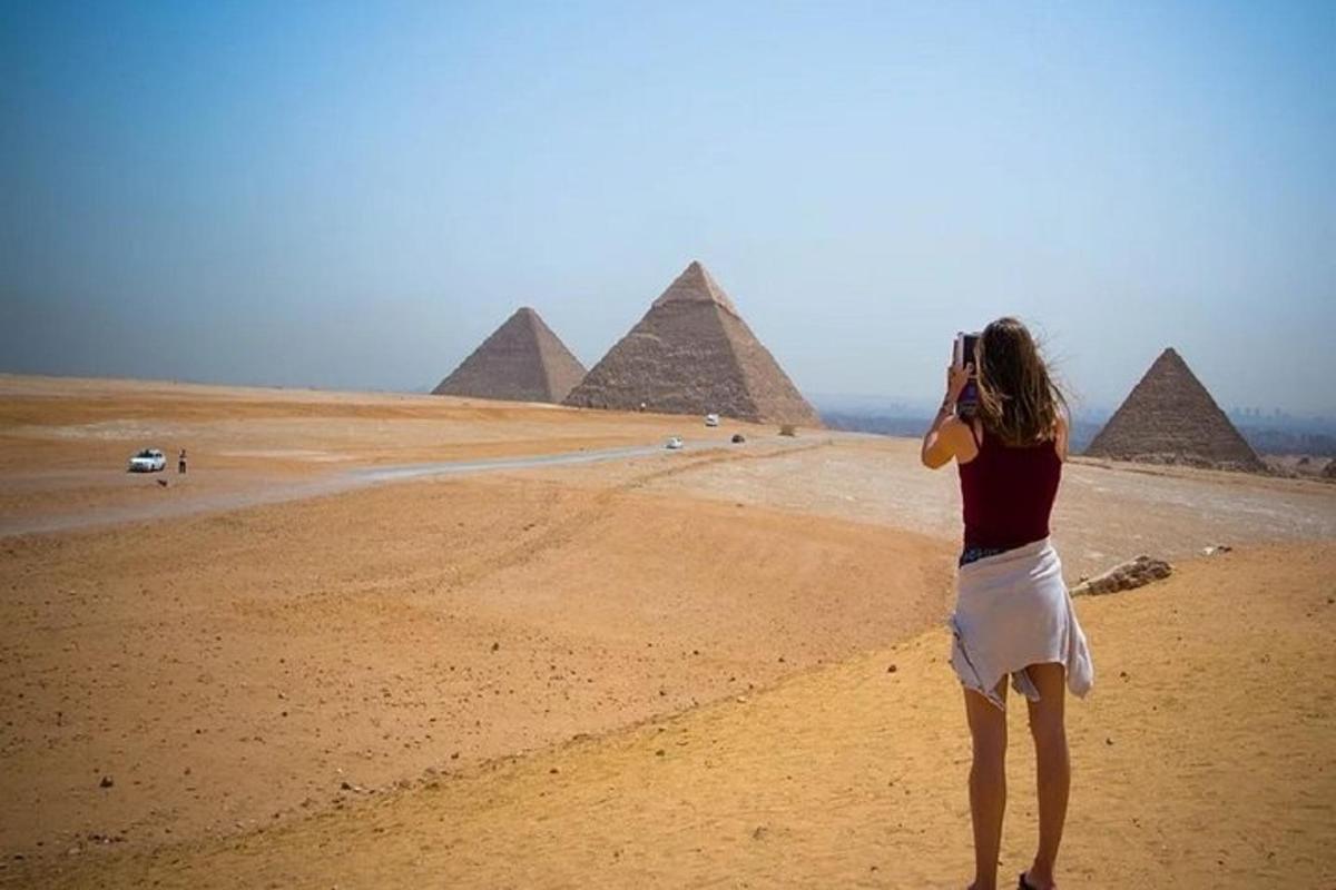 una donna che scatta una foto delle piramidi