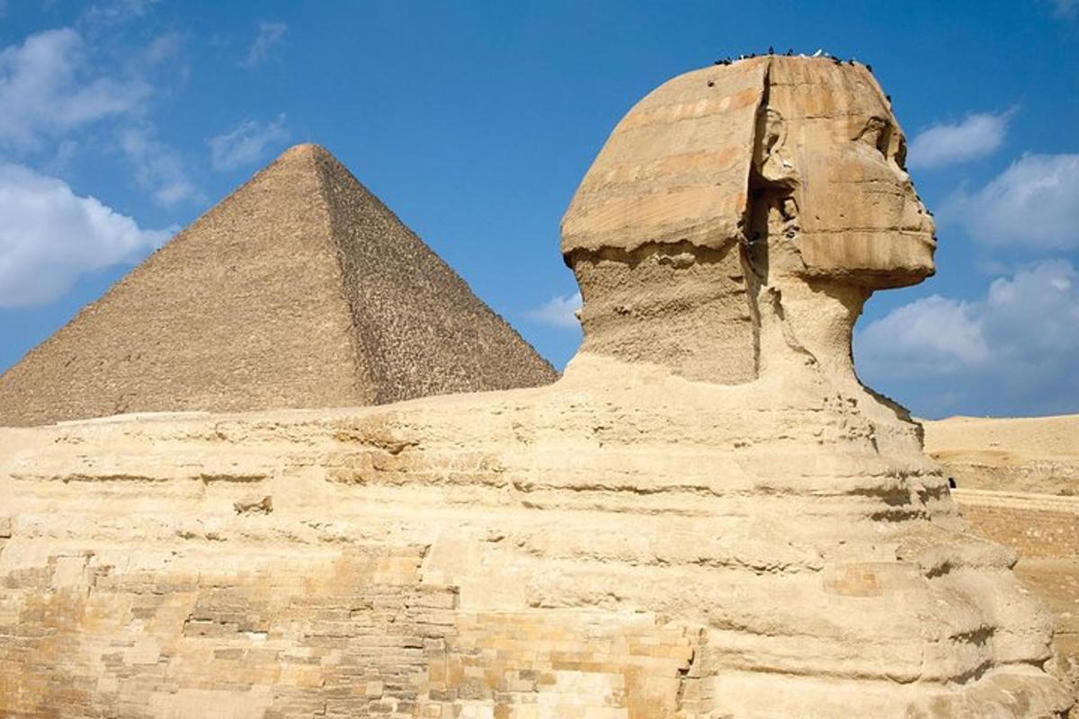 una statua di fronte alla sfinge e alla piramide