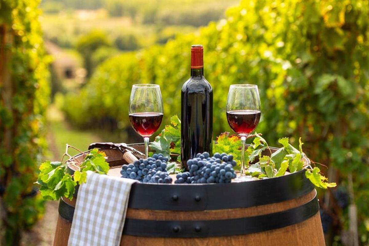 due bicchieri di vino e uva su una botte