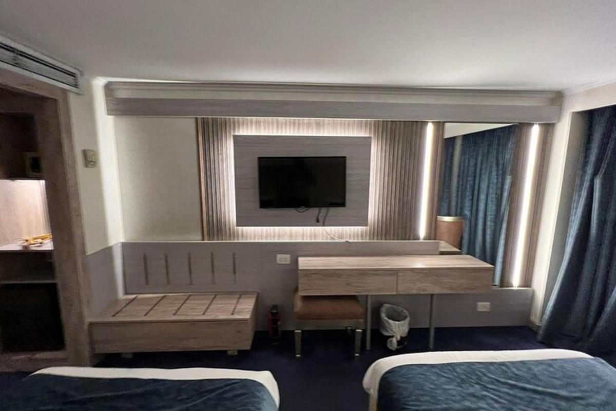 egy hotelszoba két ággyal és egy televízióval