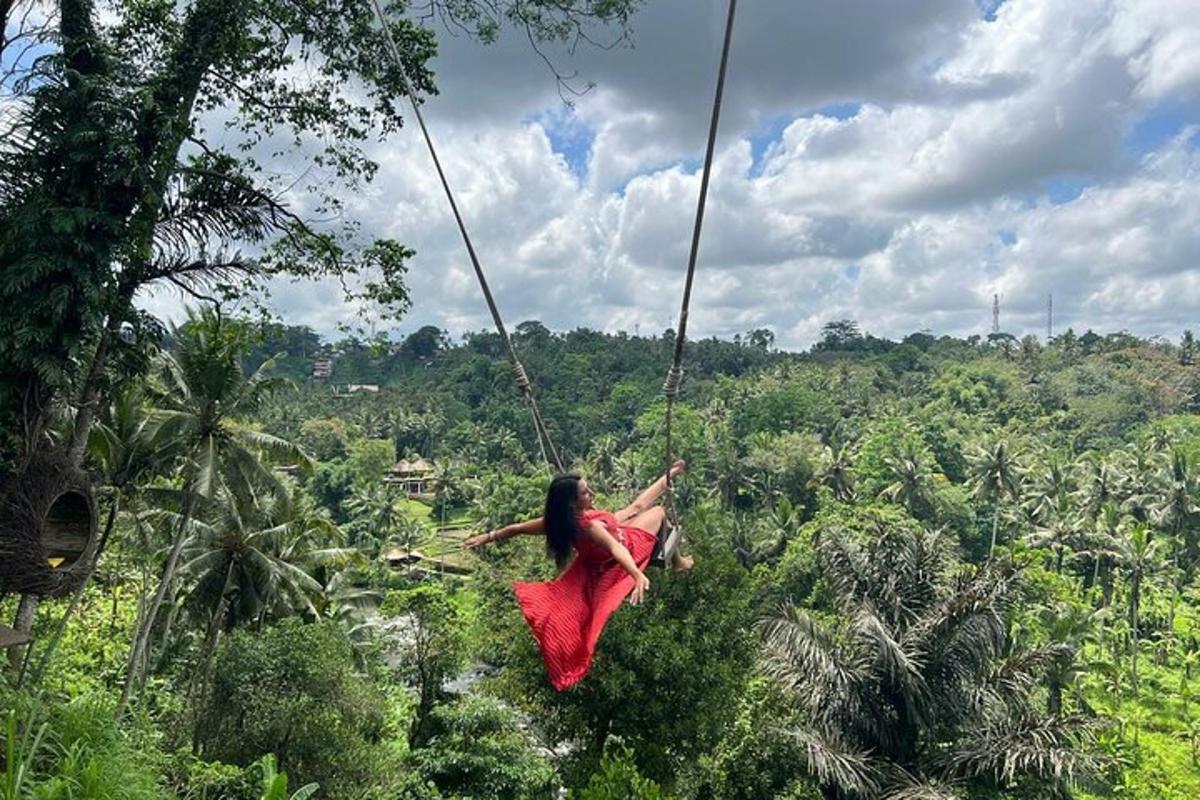 uma mulher de vestido vermelho balançando em um balanço de corda