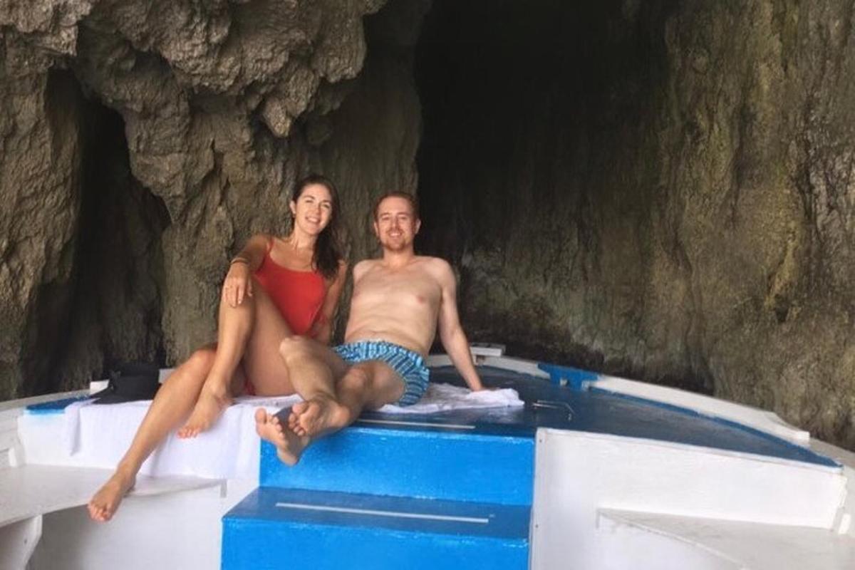 Un hombre y una mujer sentados en un bote en una cueva