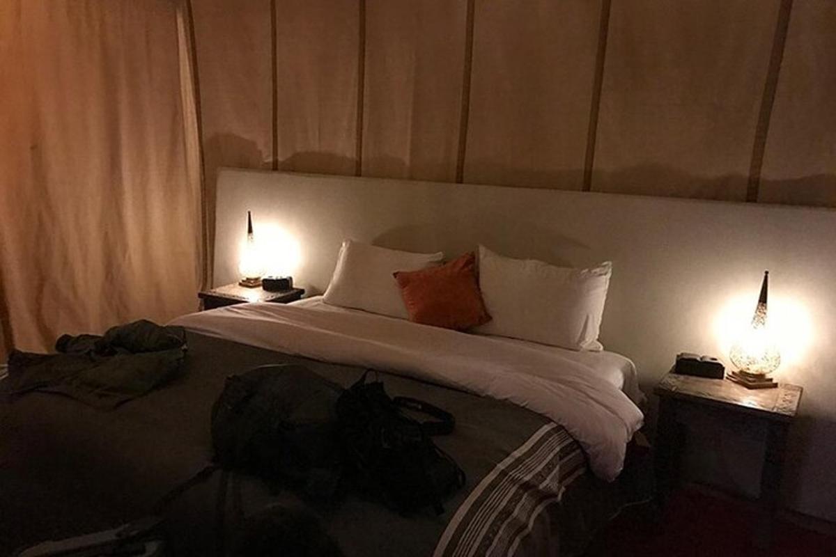 una habitació d'hotel amb un llit gran amb dos llums
