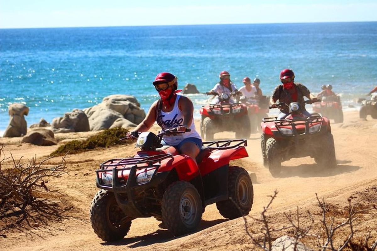 un gruppo di persone in giro su quad sulla spiaggia