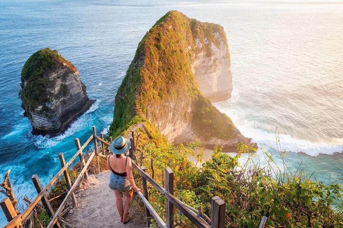 uma mulher parada em uma escada olhando para o oceano