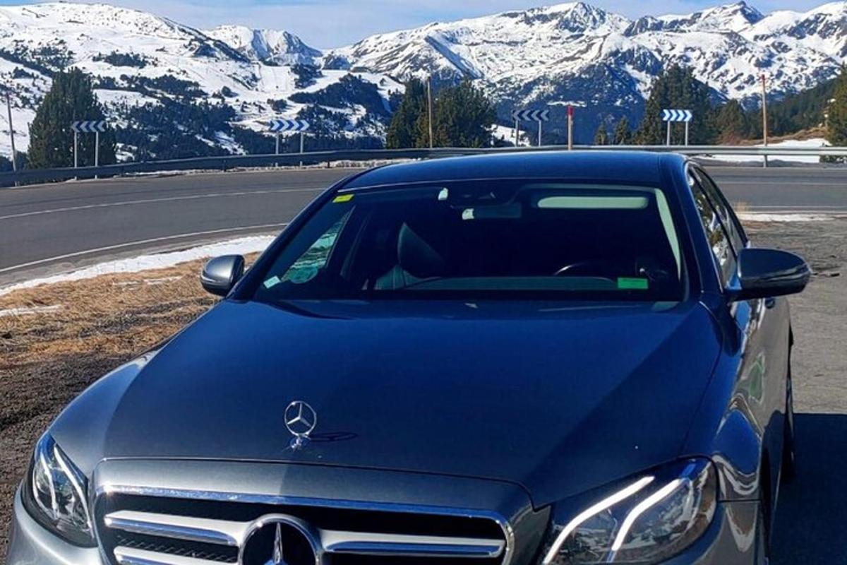 Auto Mercedes Benz zaparkované na silnici se zasněženými horami