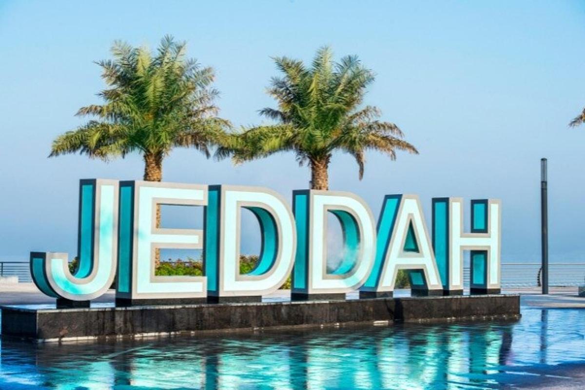 a sign that reads jedia in front of two palm trees