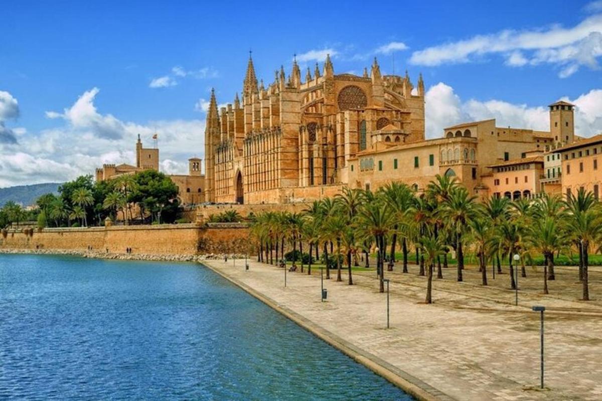 Un gran edificio con palmeras frente a un cuerpo de agua.