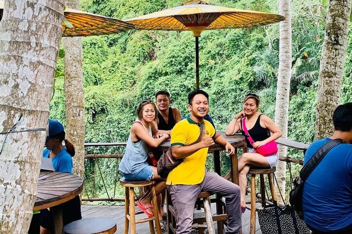 um grupo de pessoas sentadas em cadeiras sob um guarda-chuva