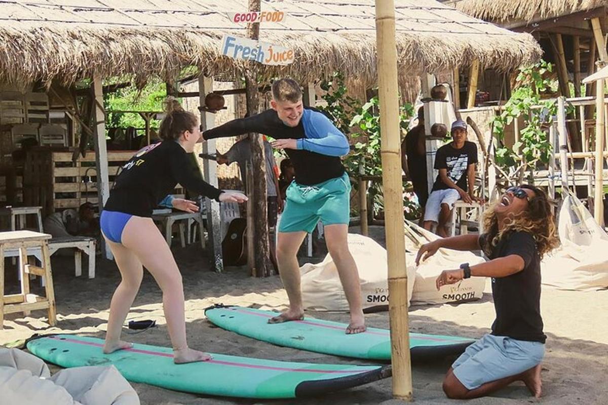 Un grupo de personas de pie sobre tablas de surf en la playa.