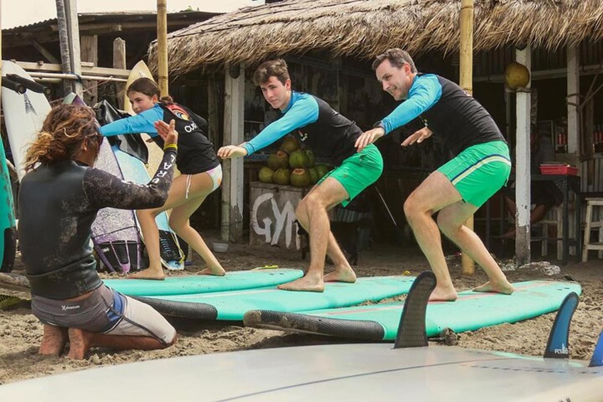 Un grupo de personas de pie sobre tablas de surf en la playa.