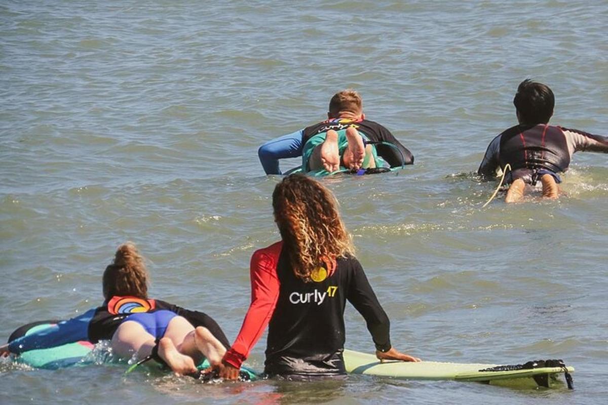 Un grupo de personas sentadas en tablas de surf en el agua.