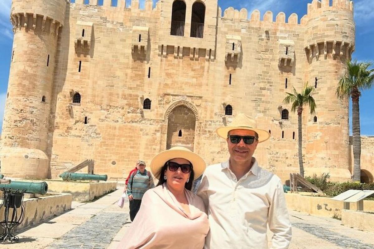 a man and woman standing in front of a castle