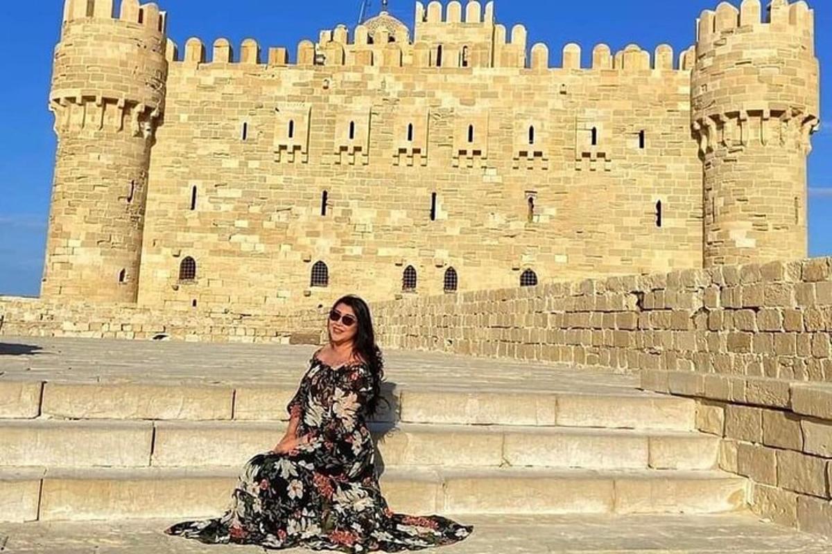 a woman sitting on steps in front of a castle