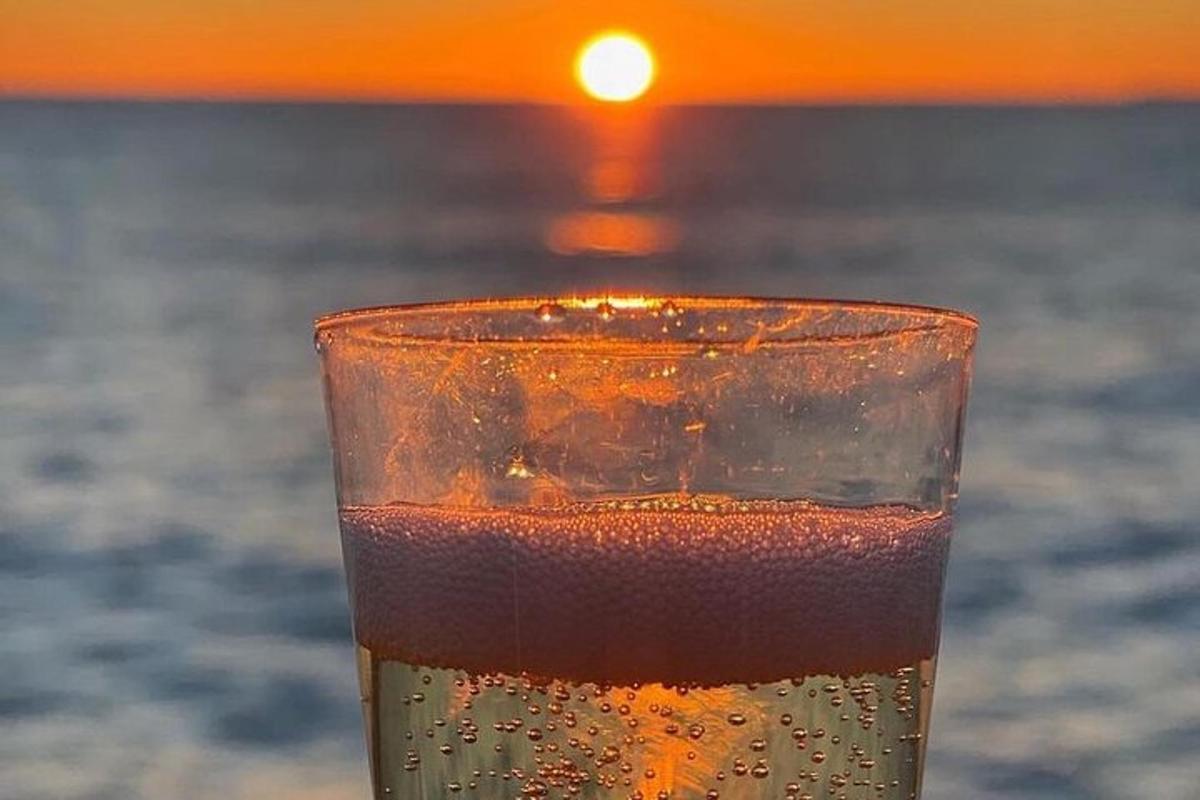 uma taça de champanhe com o pôr do sol ao fundo