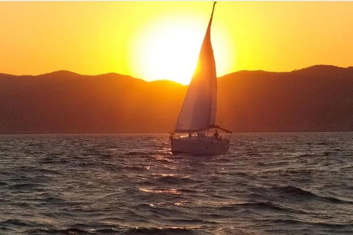 um veleiro no oceano ao pôr do sol