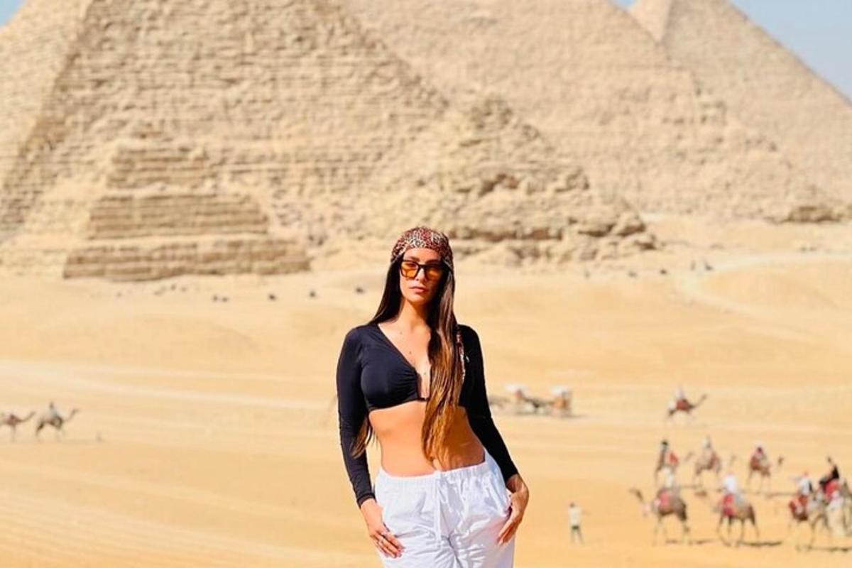 a woman standing in front of the pyramids