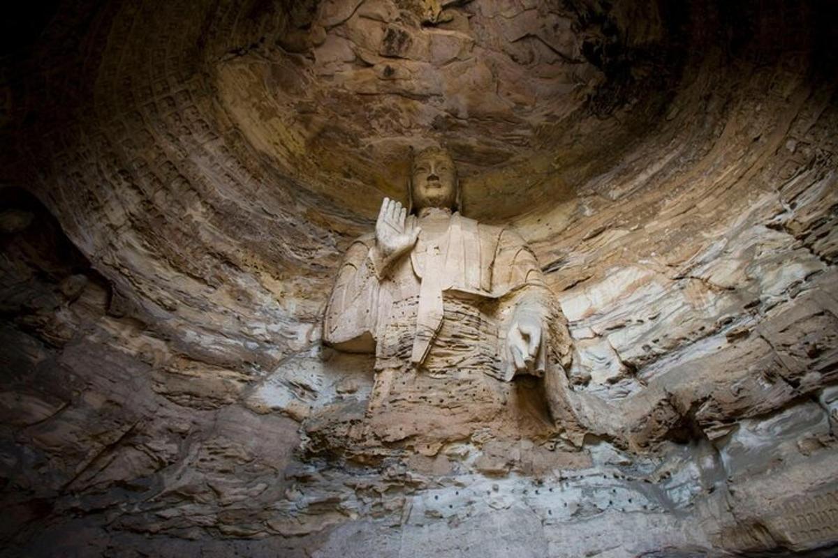 o statuie a unui bărbat așezat pe un perete