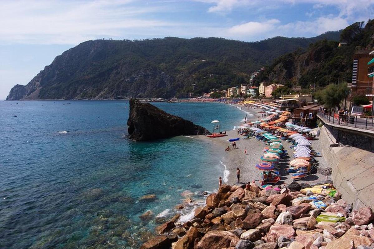 una playa con sombrillas y gente en el agua