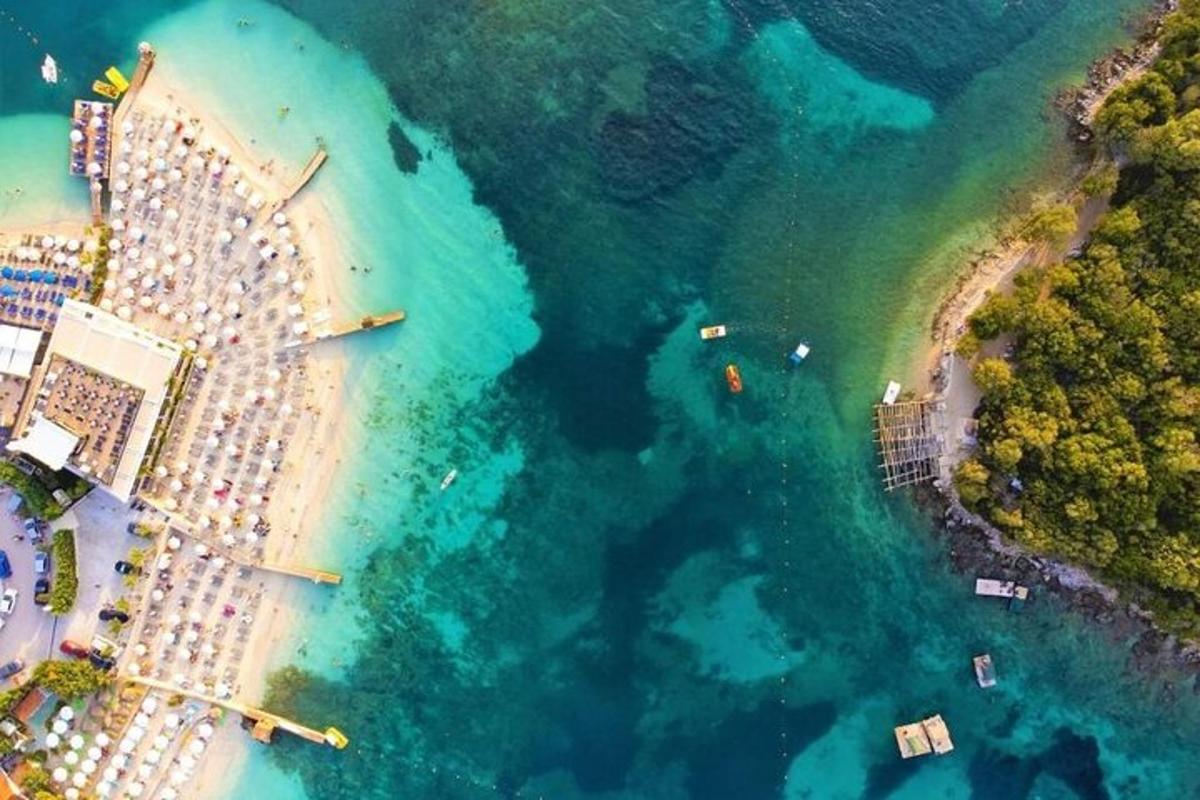 an aerial view of a beach with boats in the water