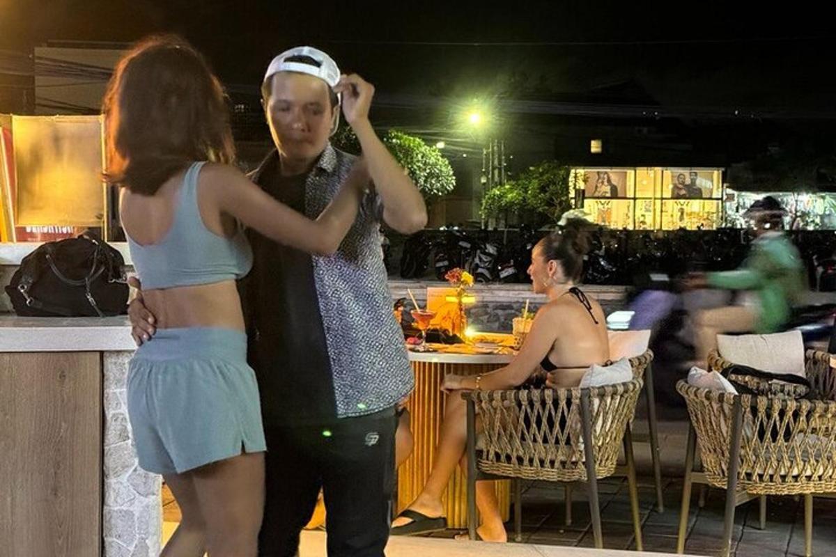 a couple of girls standing next to a bar