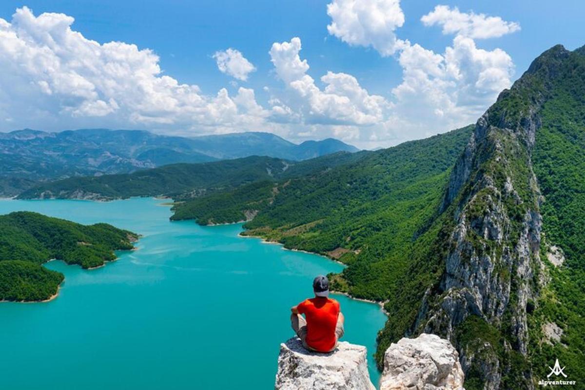 a man sitting on a rock overlooking a lake