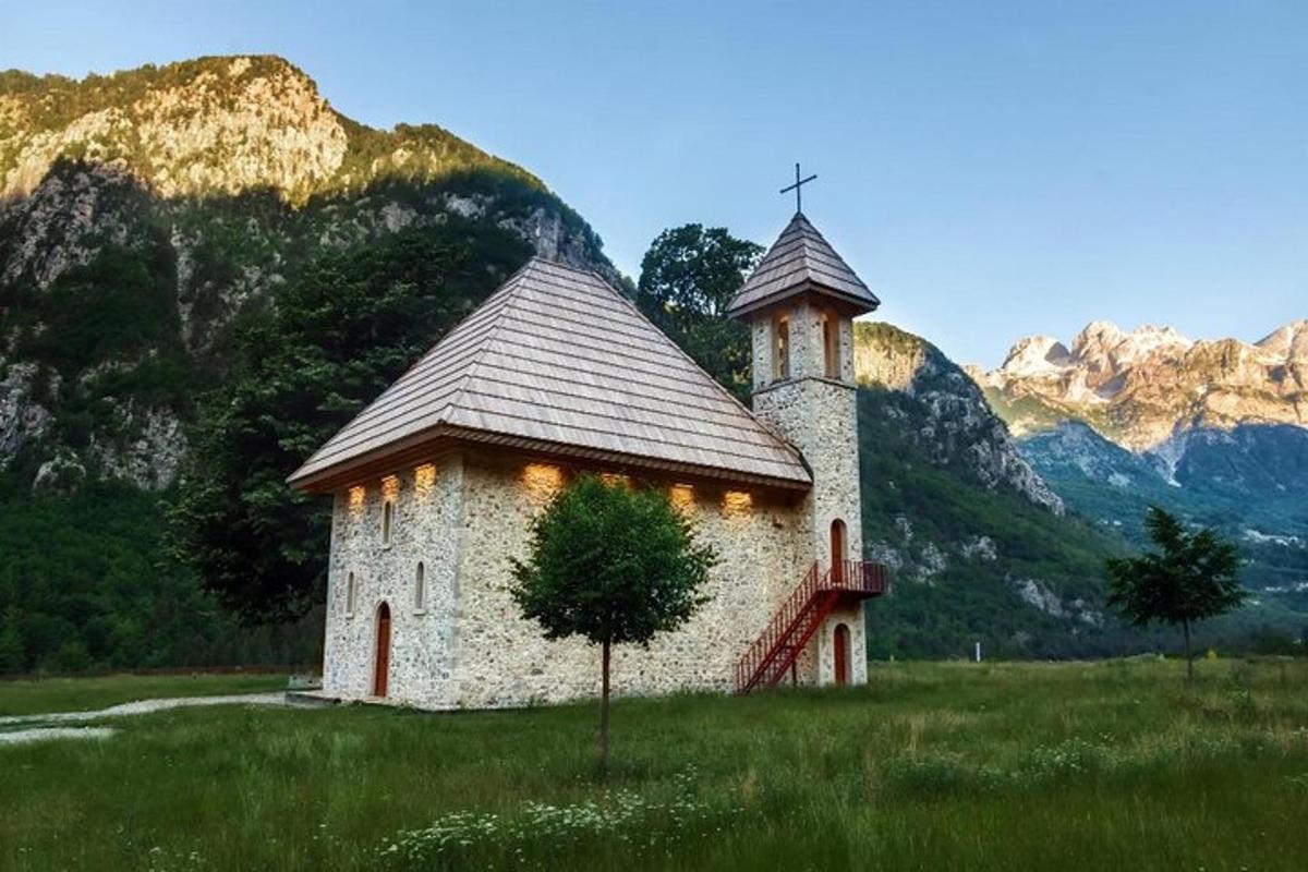 sebuah gereja di padang dengan latar belakang gunung