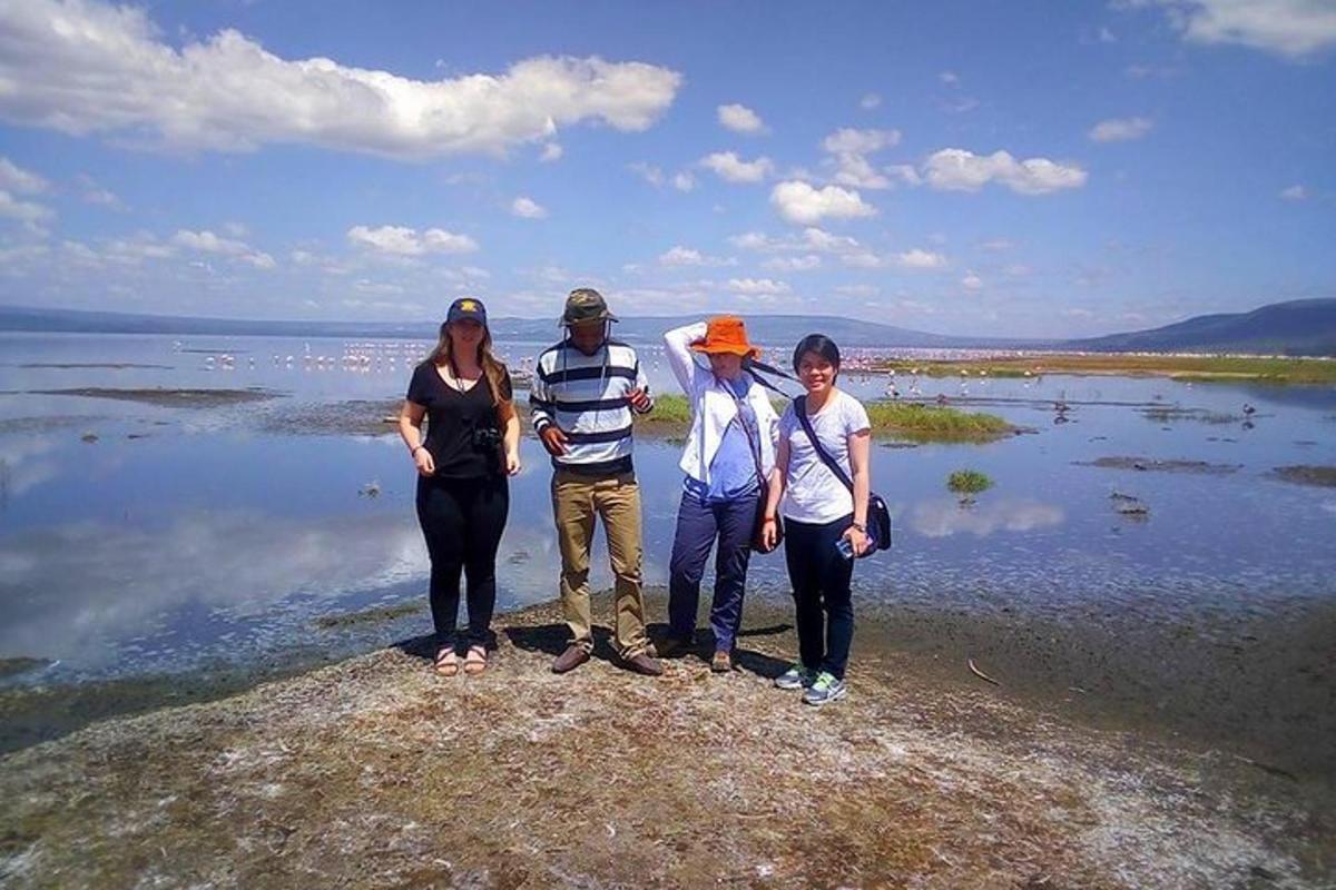 un gruppo di persone in piedi su una roccia vicino all'acqua
