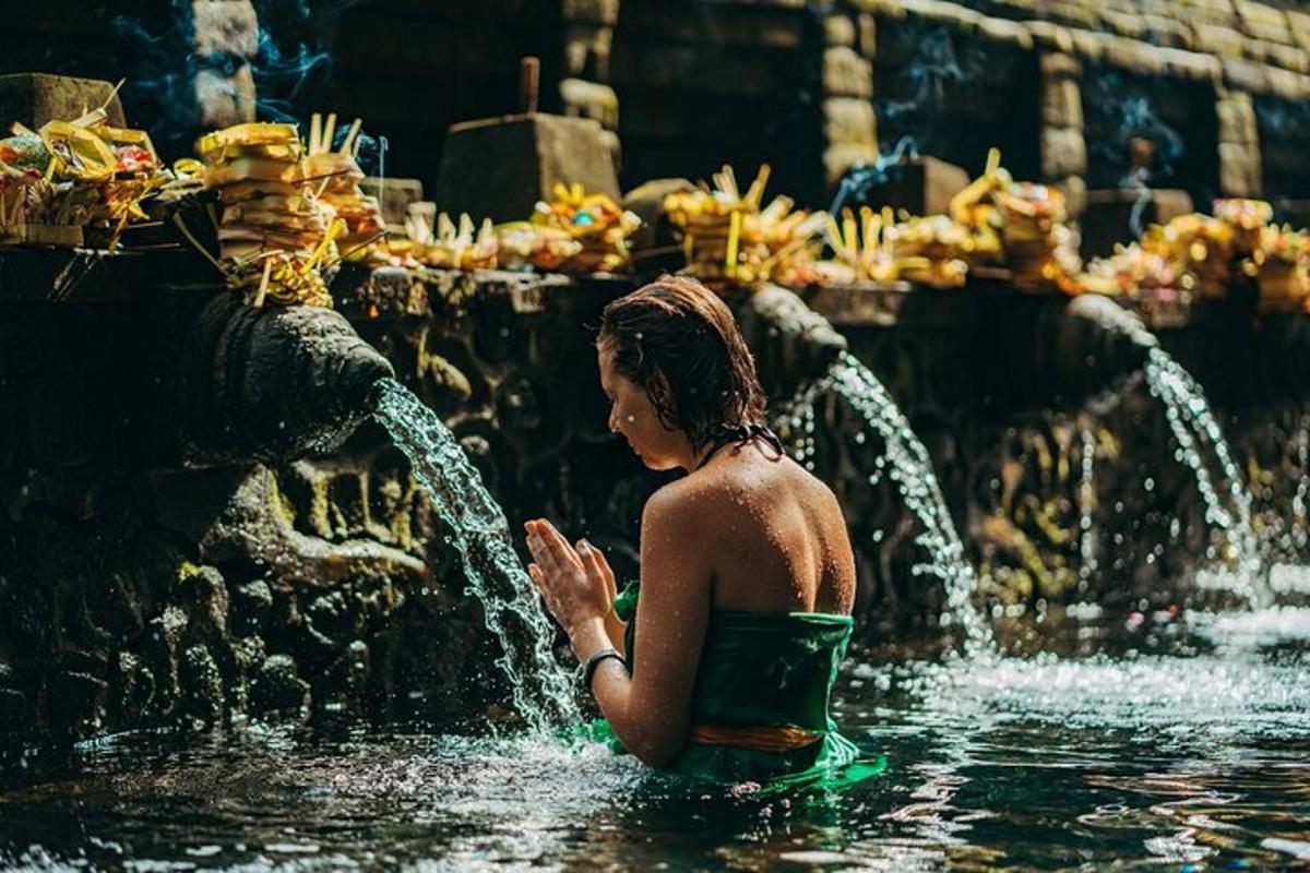 一名女子站在喷泉水中