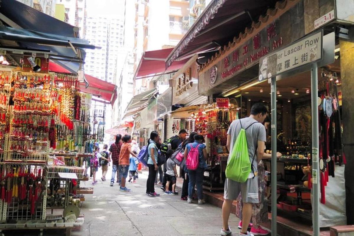 a group of people walking through a street with shops