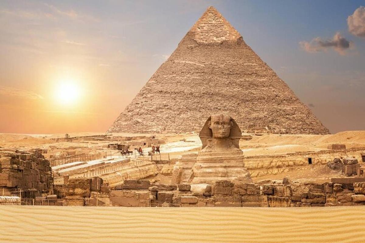 una piramide e una statua di fronte alle piramidi