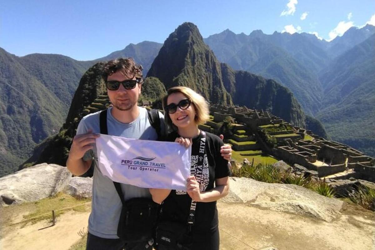 un uomo e una donna con un cartello a Machu Picchu
