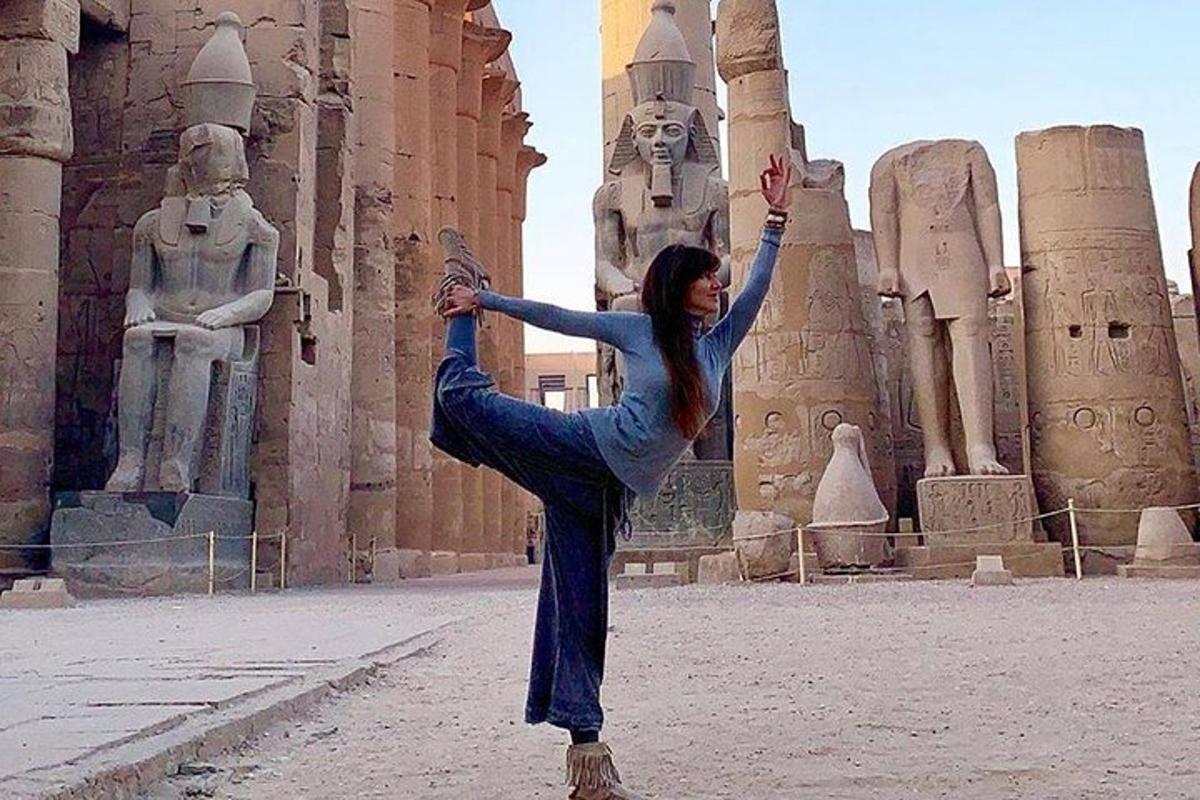 eine Frau, die vor einem Tempel eine Yoga-Pose macht
