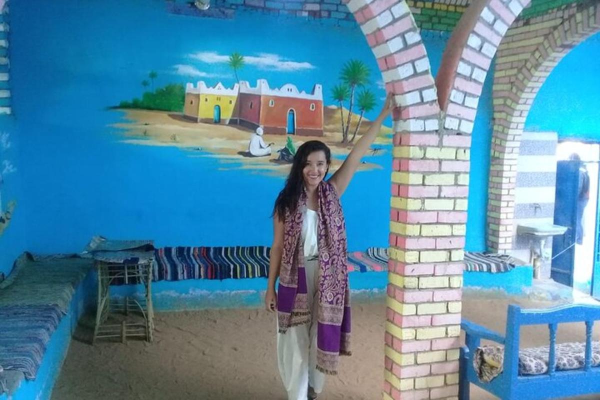 uma jovem parada em frente a um mural
