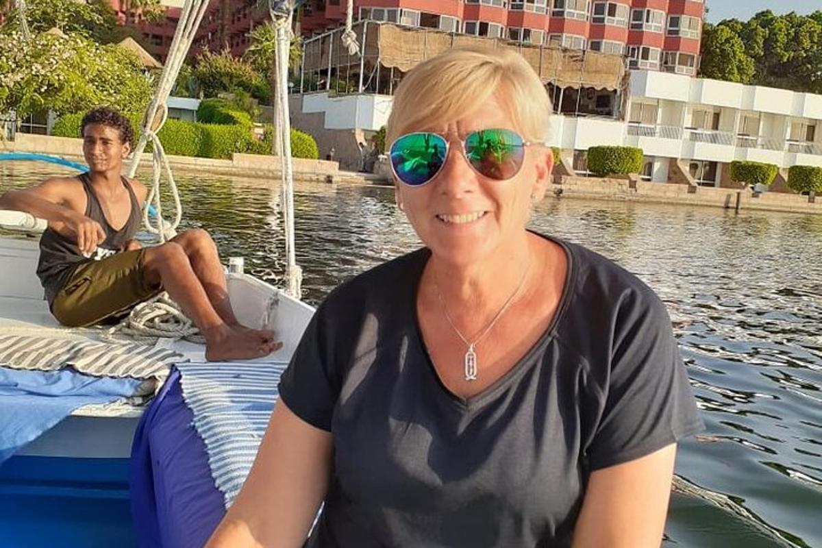 kona með sólgleraugu sitjandi á báti í vatninu