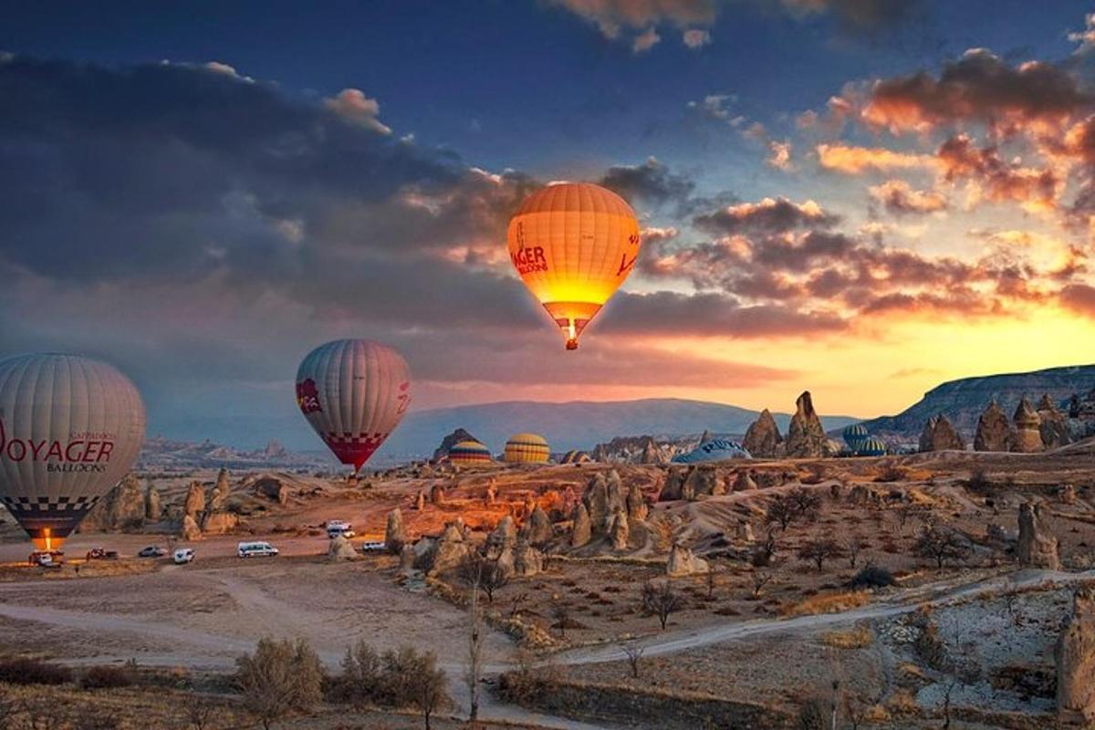 un gruppo di mongolfiere che sorvolano una formazione rocciosa