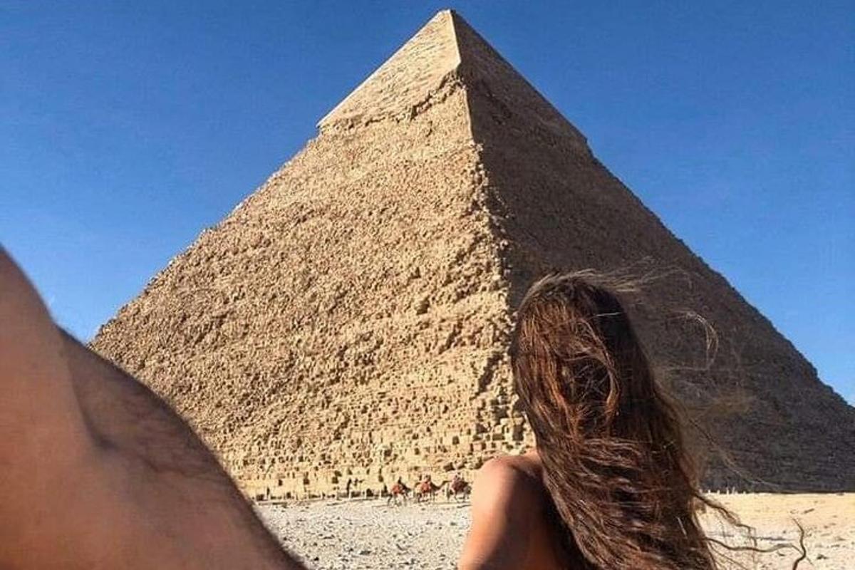 una persona in piedi di fronte a una piramide