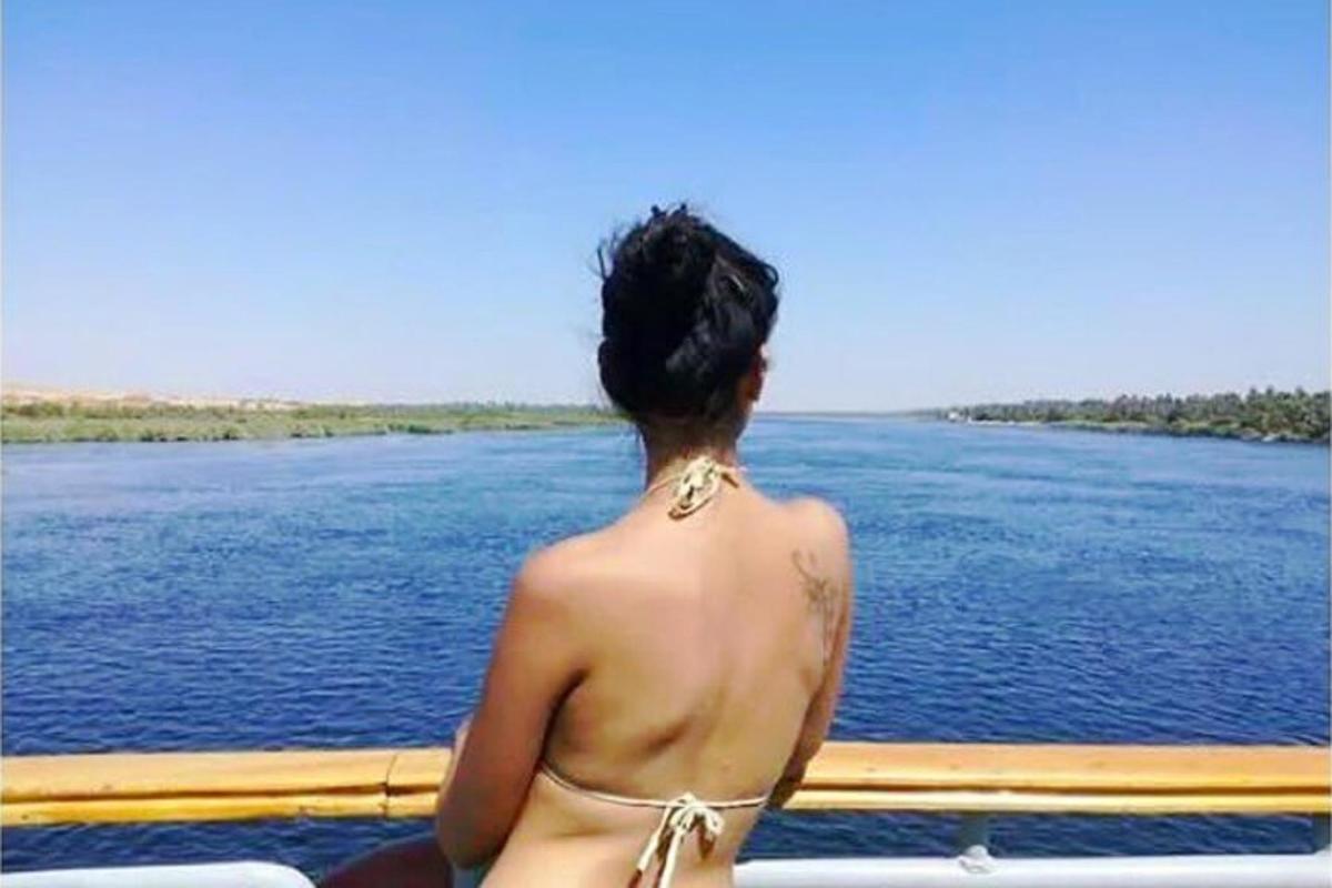 una donna in bikini che guarda uno specchio d'acqua