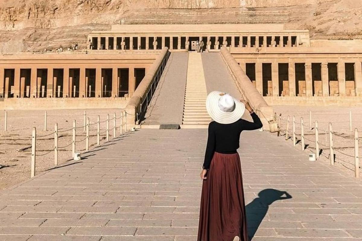 una donna con un cappello in piedi davanti a un edificio