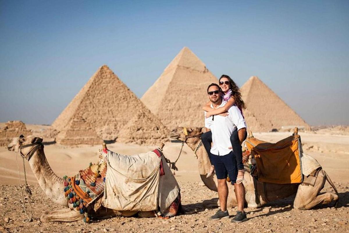 en mann og en kvinne som poserer foran pyramidene
