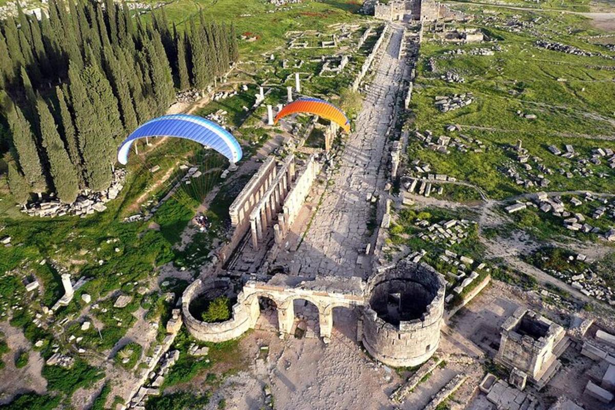 an aerial view of a building with parachutes flying over it