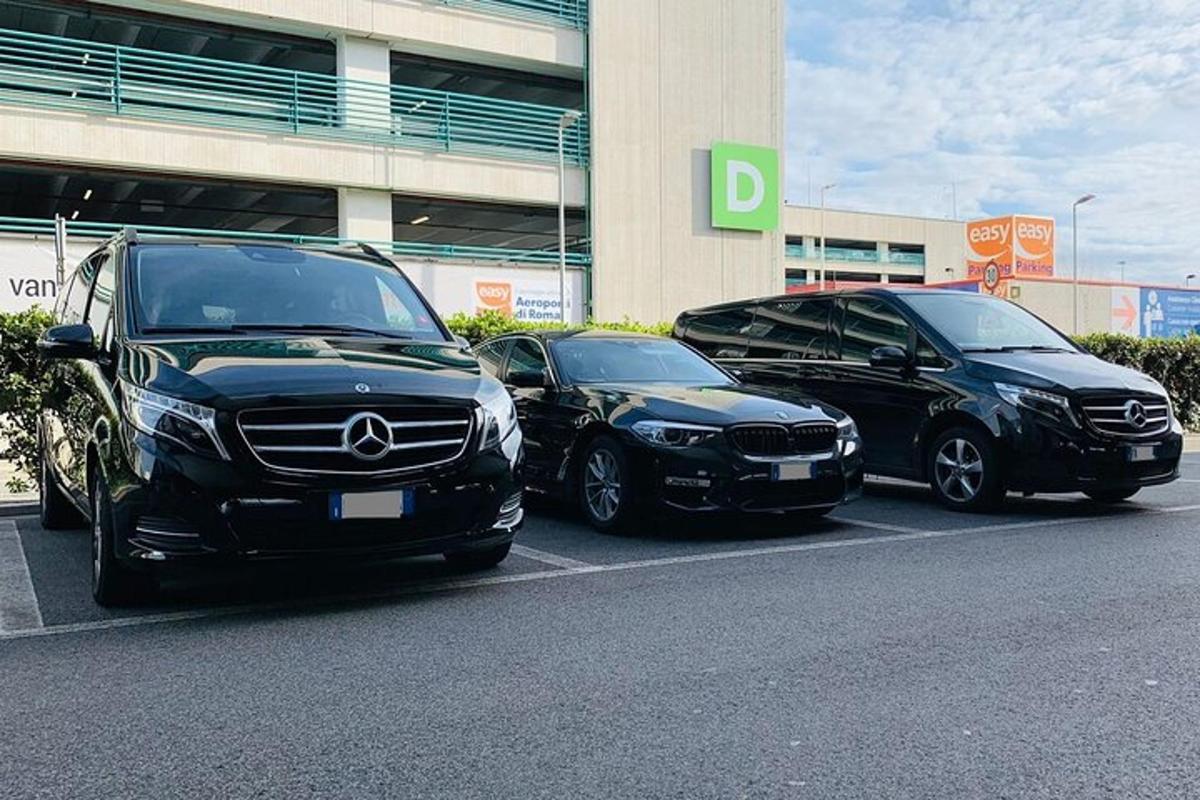 tři auta zaparkovaná na parkovišti před budovou