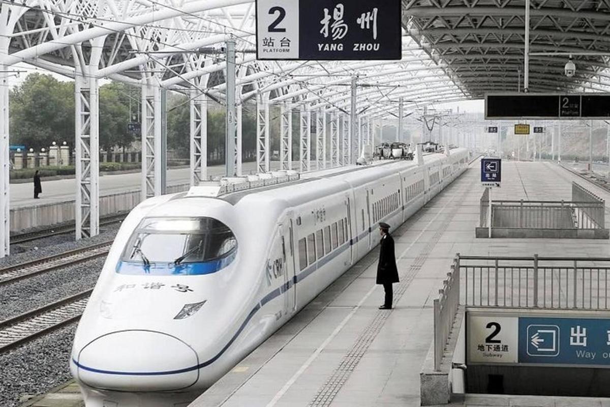 a person standing next to a train at a train station