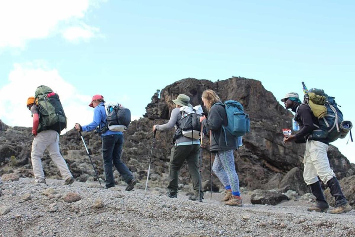 en gruppe mennesker som vandrer på et steinete fjell