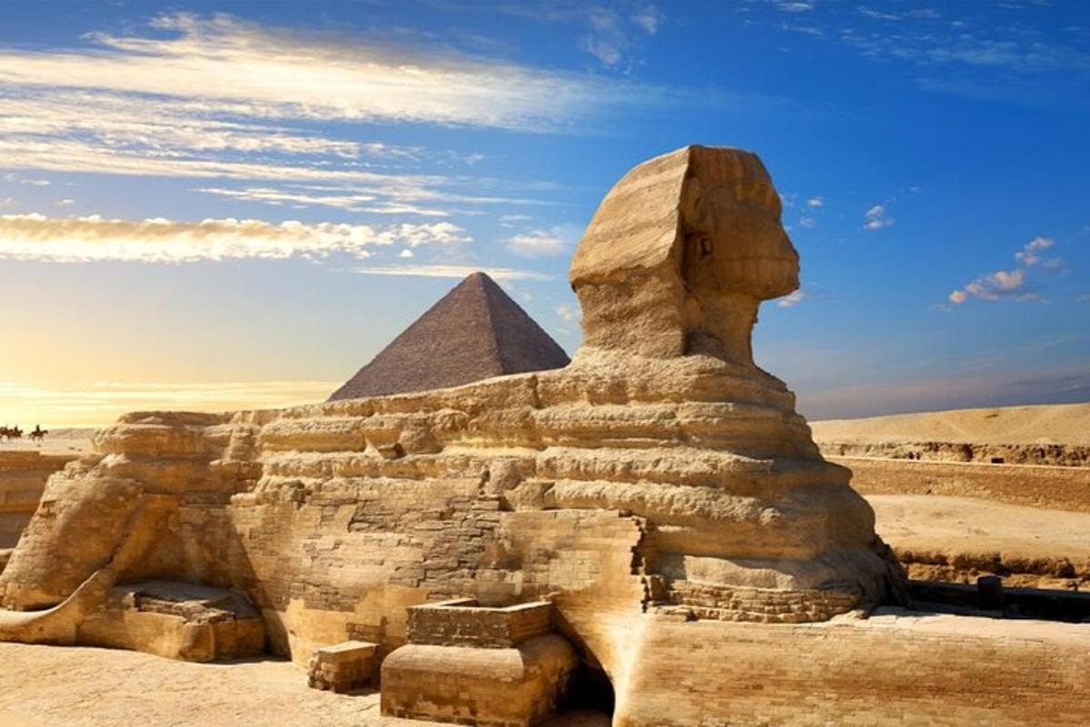 a statue in front of the sphinx and pyramid