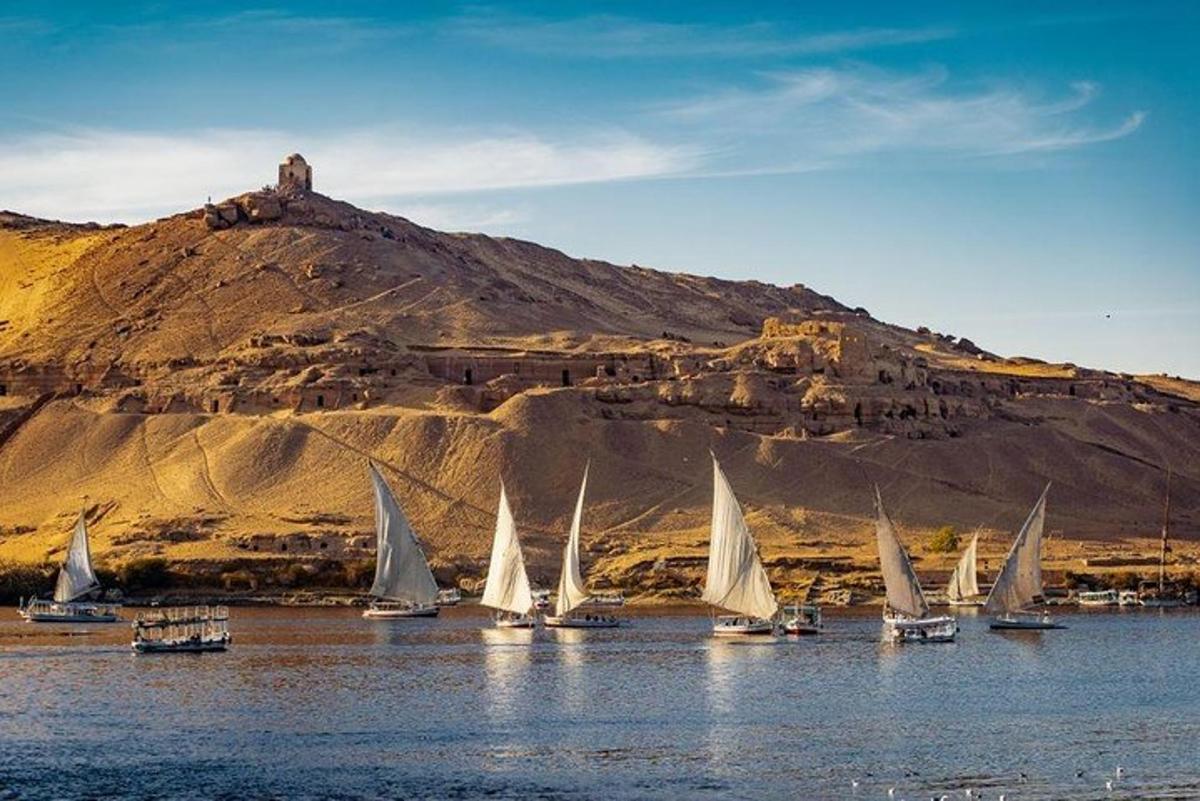 sekumpulan perahu layar di atas air dengan gunung