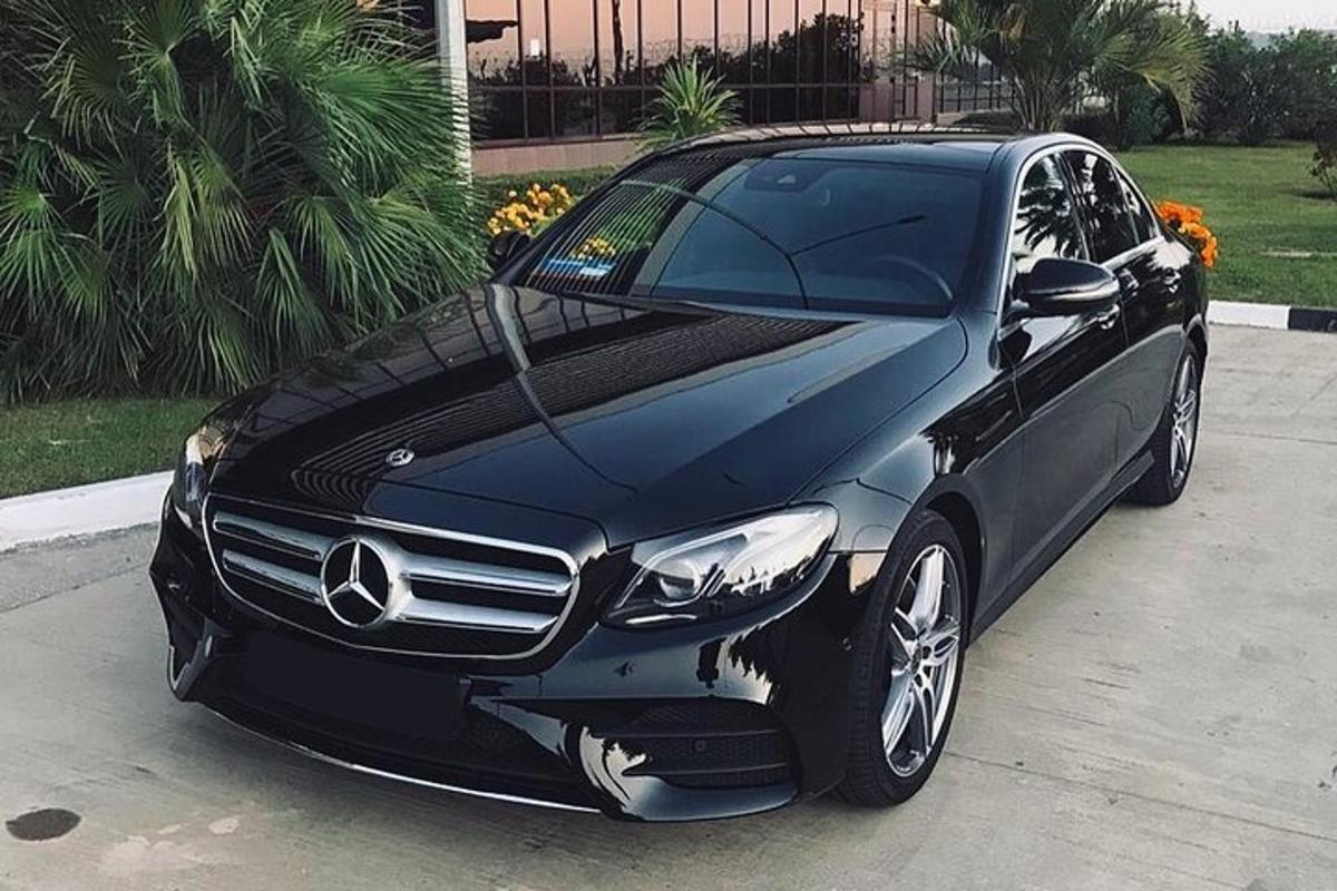 Černé auto Mercedes Benz zaparkované na příjezdové cestě