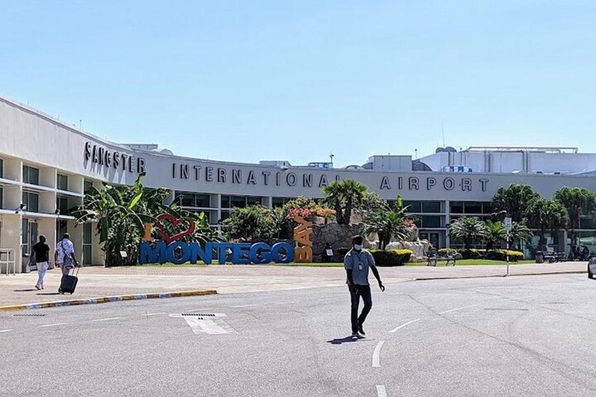 un uomo che attraversa la strada di fronte a un aeroporto
