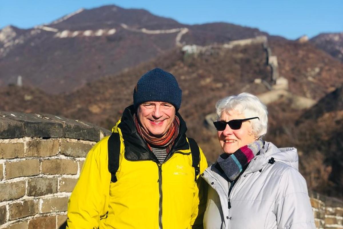 two people standing on top of the great wall